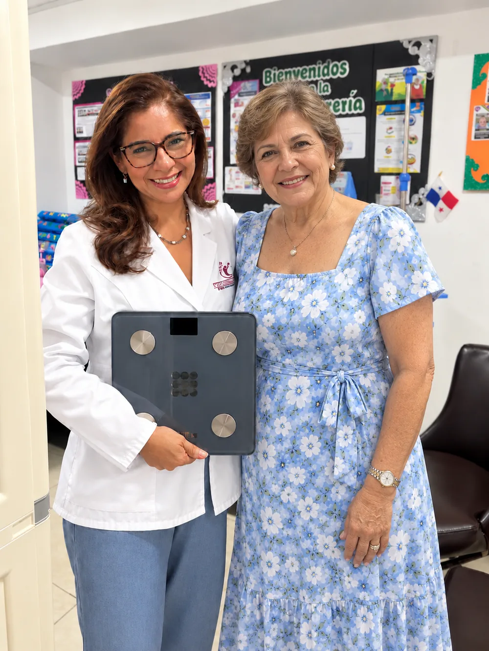 Mgtr. Claudia Bonilla con una paciente, sosteniendo una báscula de composición corporal