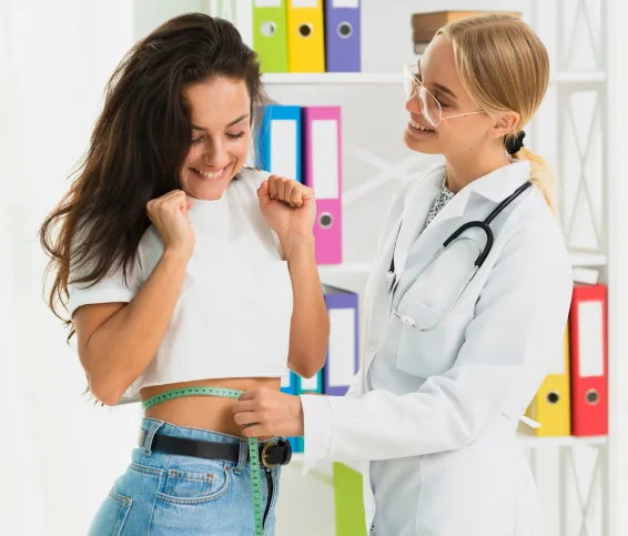 Nutricionista midiendo la cintura de una paciente durante una consulta
